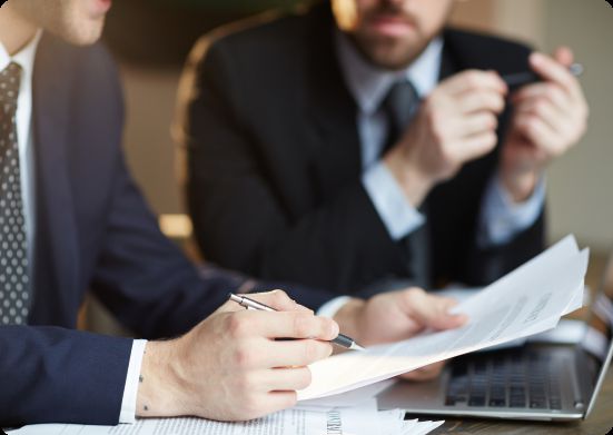 Profissionais analisando documentos durante uma reunião de assessoria